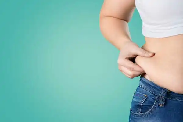Image of woman pinching her love handles to show weight gain Rochford